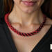 Close-up of model wearing Crimson Noir Kumihimo beaded necklace with red and black glass seed beads against black dress
